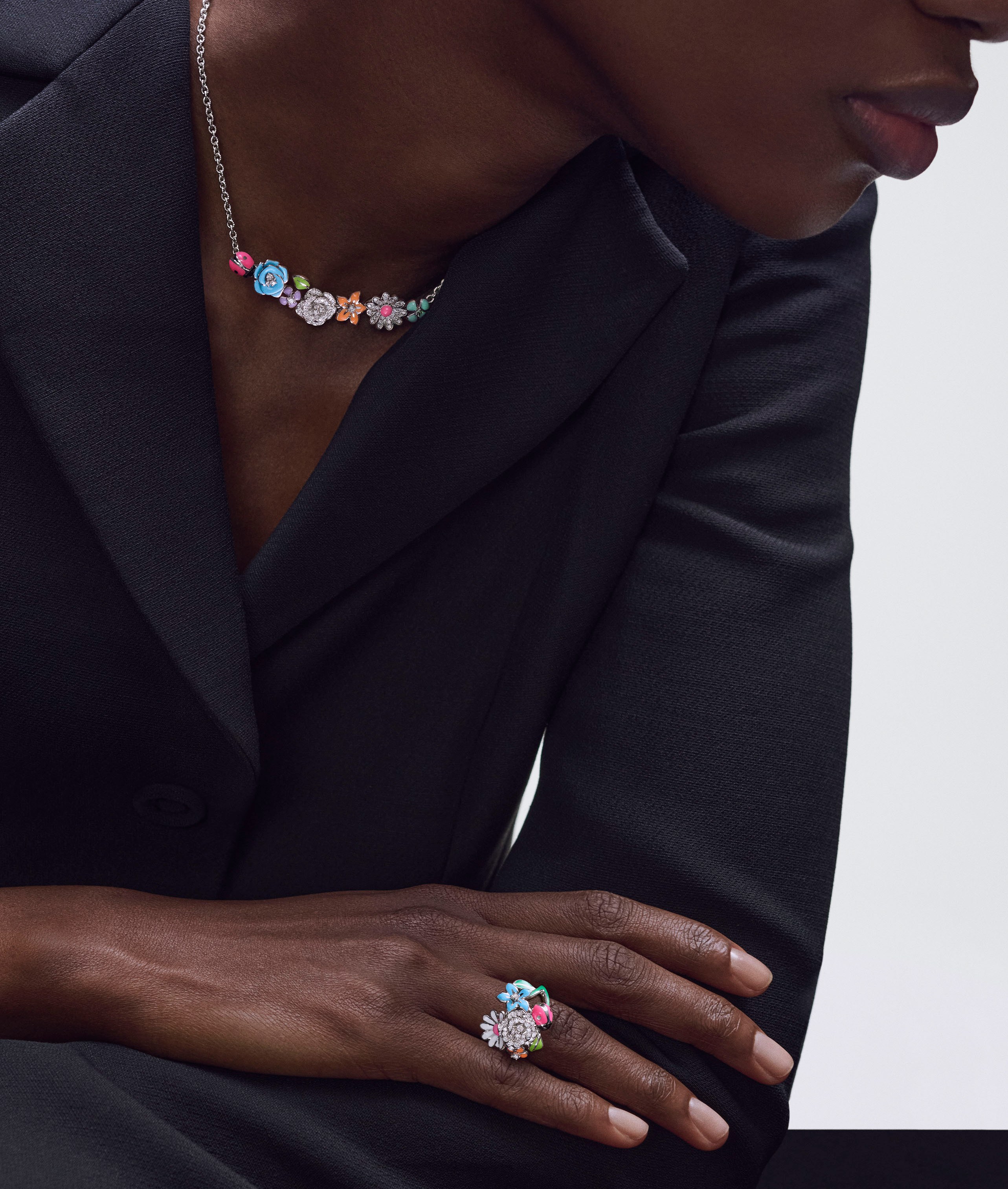 Person wearing a floral necklace and ring.
