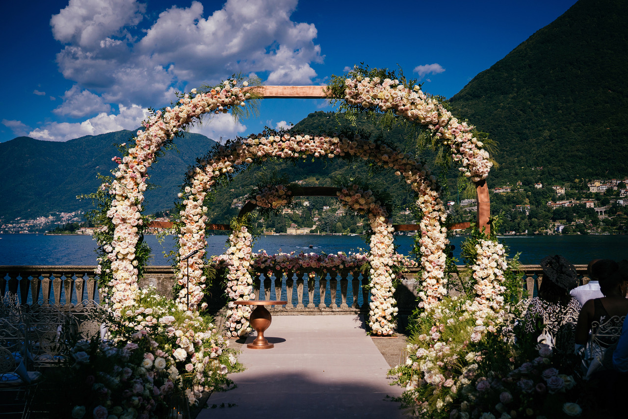 Floral wedding arch overlooking a lake and mountains.